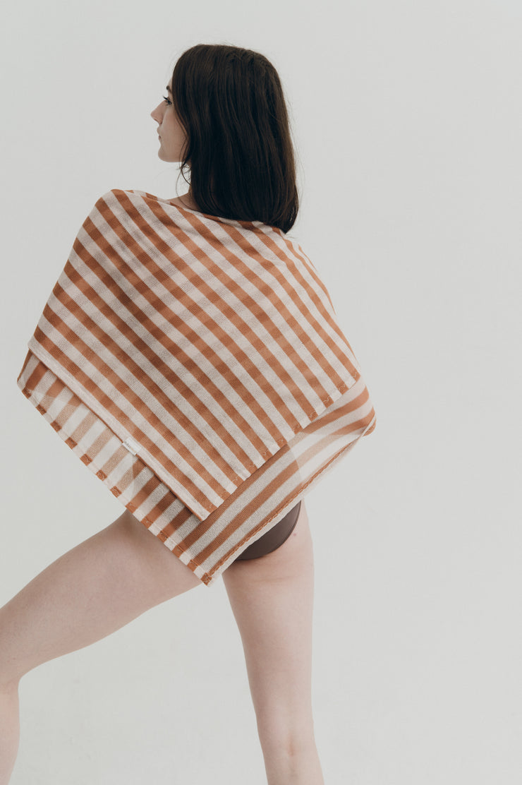 Woman wearing a striped shawl on a plain background