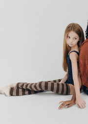Two women sitting on a white floor in casual attire