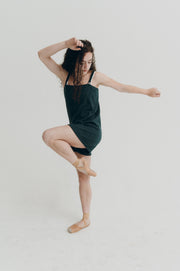 Woman in a green romper posing on a white background