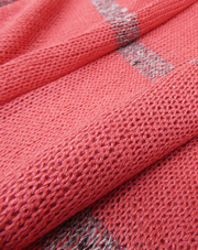 Close-up of coral jumper with a striped pattern