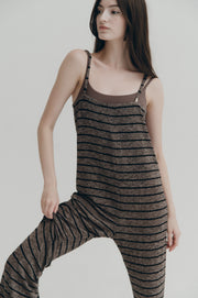 Woman wearing a brown and black striped outfit on a plain background