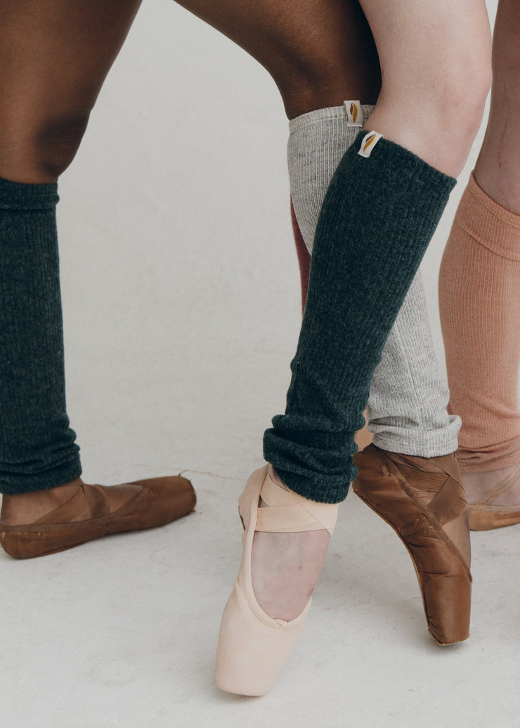 Models wearing leg warmers against a plain background